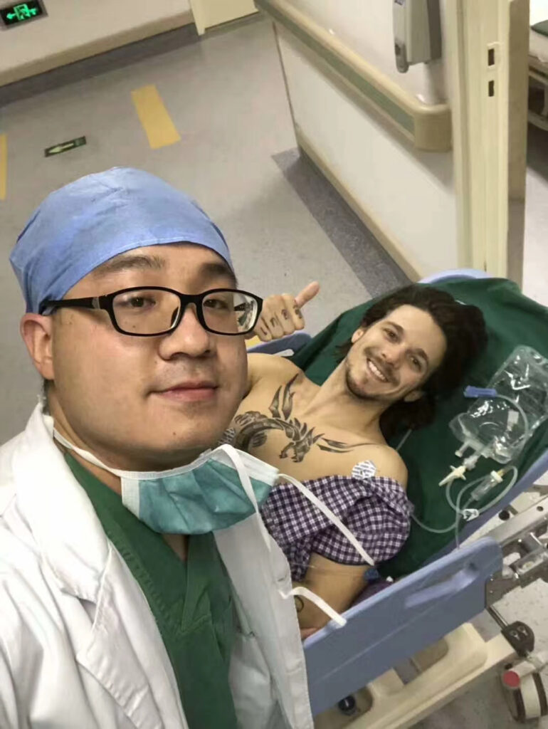 Stefan in hospital bed with surgeon, prepped for surgery